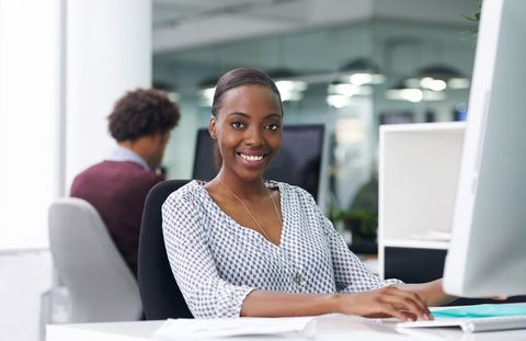 Woman Smiling while working on computer