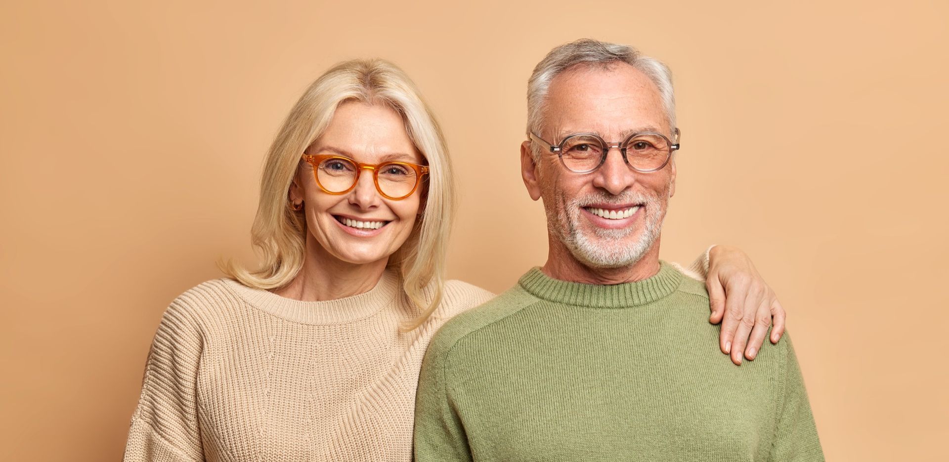 A man and a woman wearing glasses are posing for a picture.