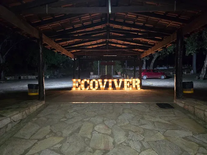 Vista noturna da entrada de um prédio com a palavra 