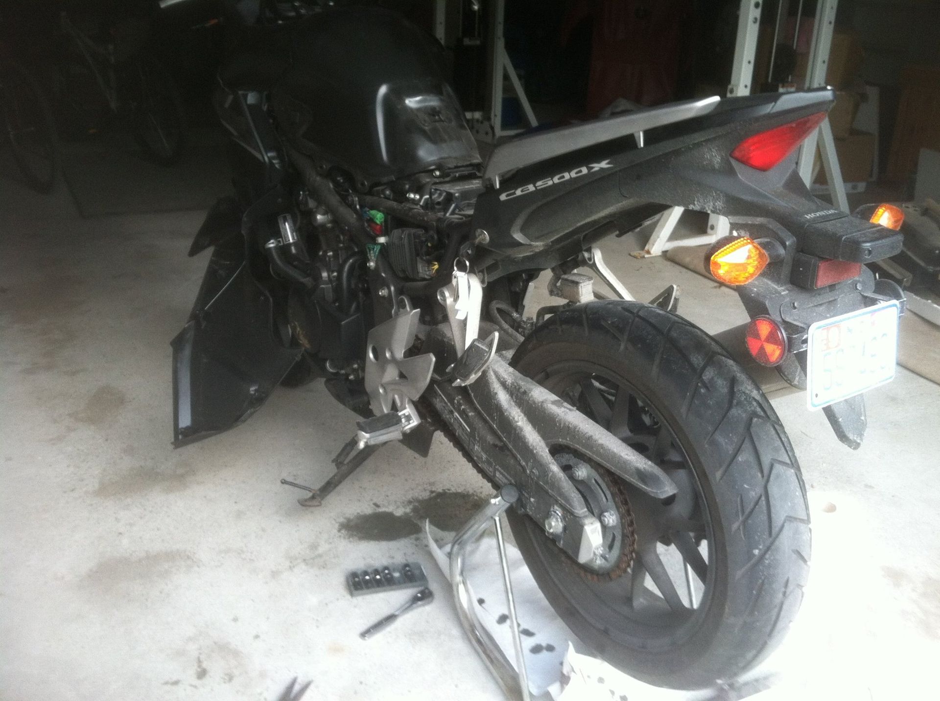 A motorcycle is sitting on a ramp in a garage.