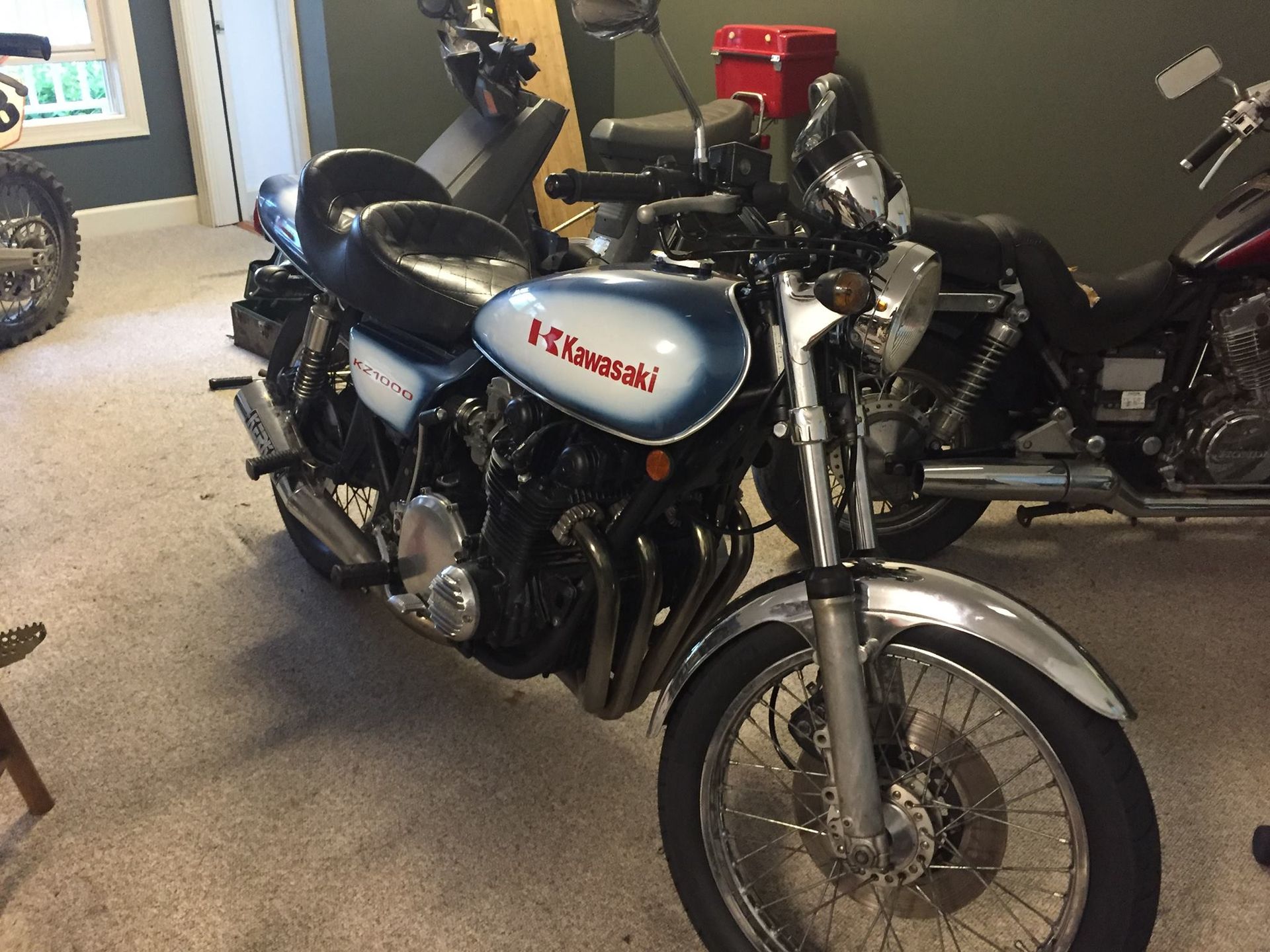 A kawasaki motorcycle is parked in a garage
