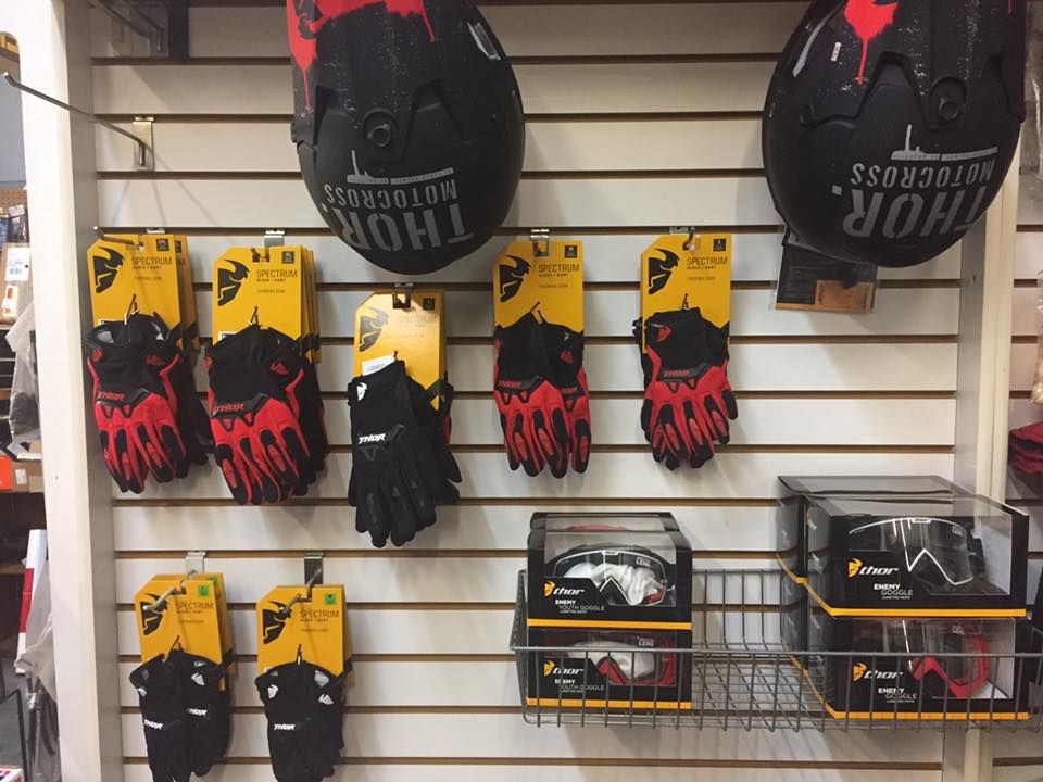 A display of thor helmets and gloves on a wall
