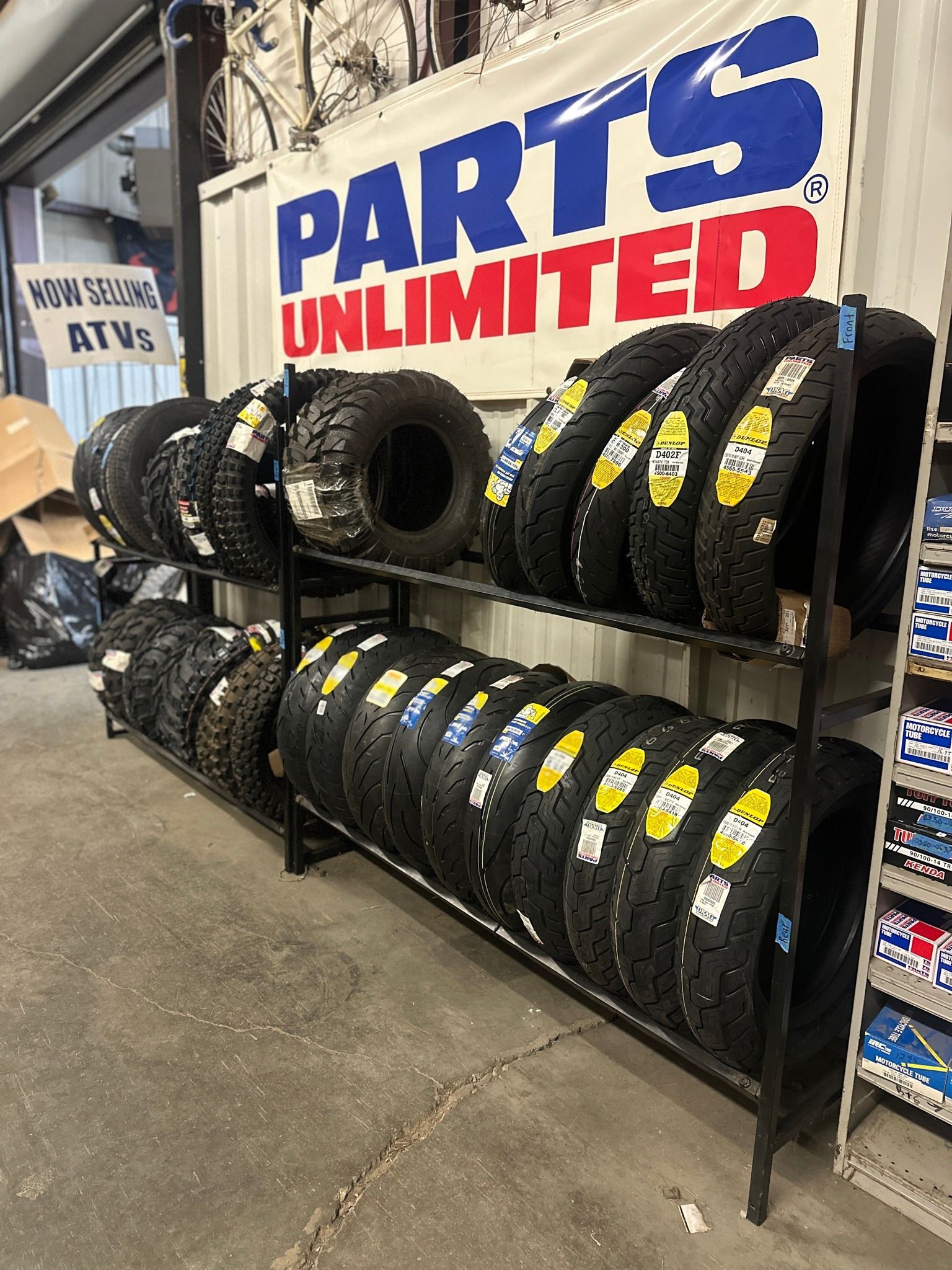 A store filled with lots of tires and a sign that says parts unlimited