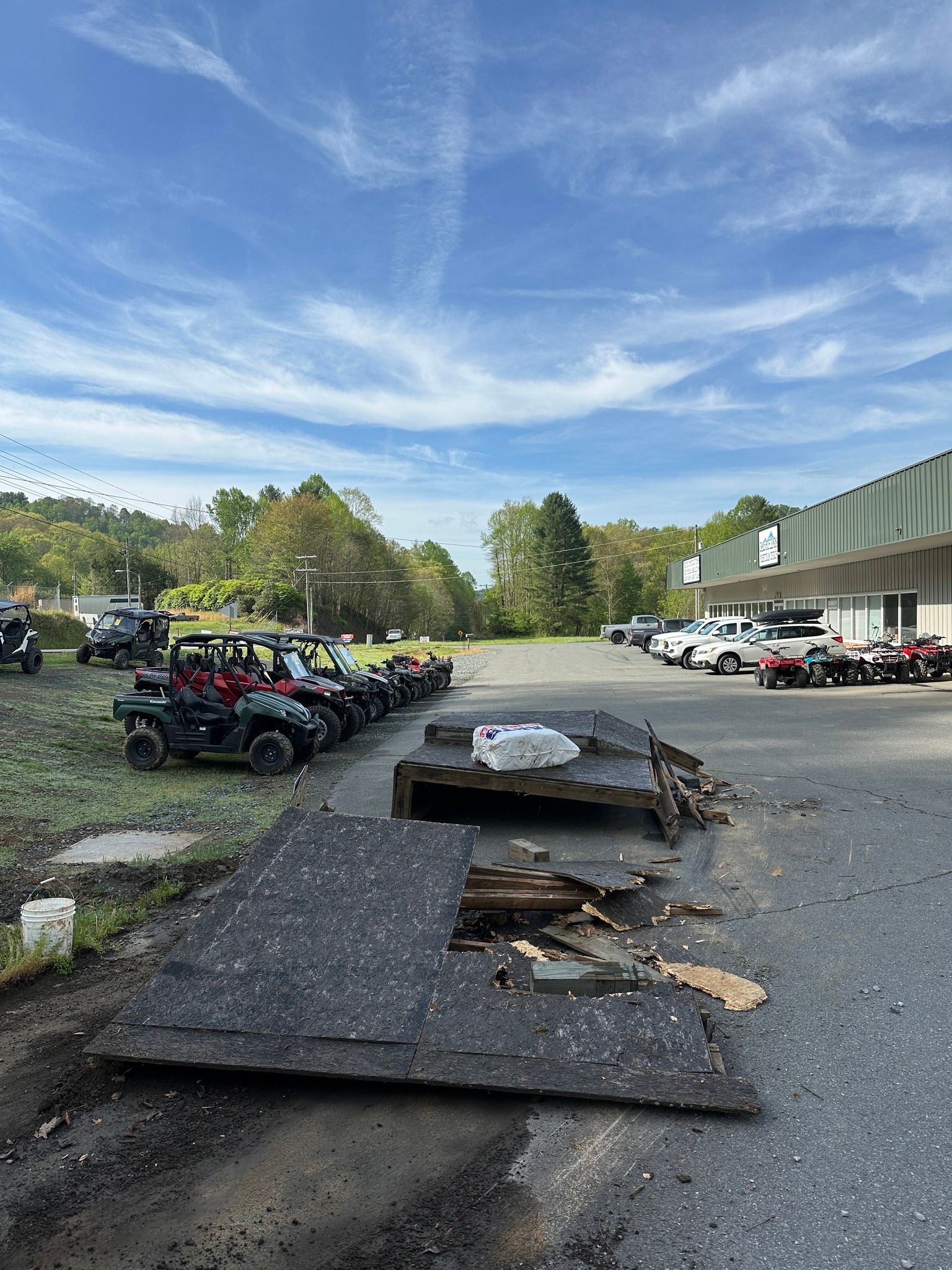 A row of atvs are parked in a parking lot in front of a building.