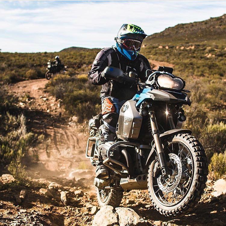 A man is riding a motorcycle on a dirt road.