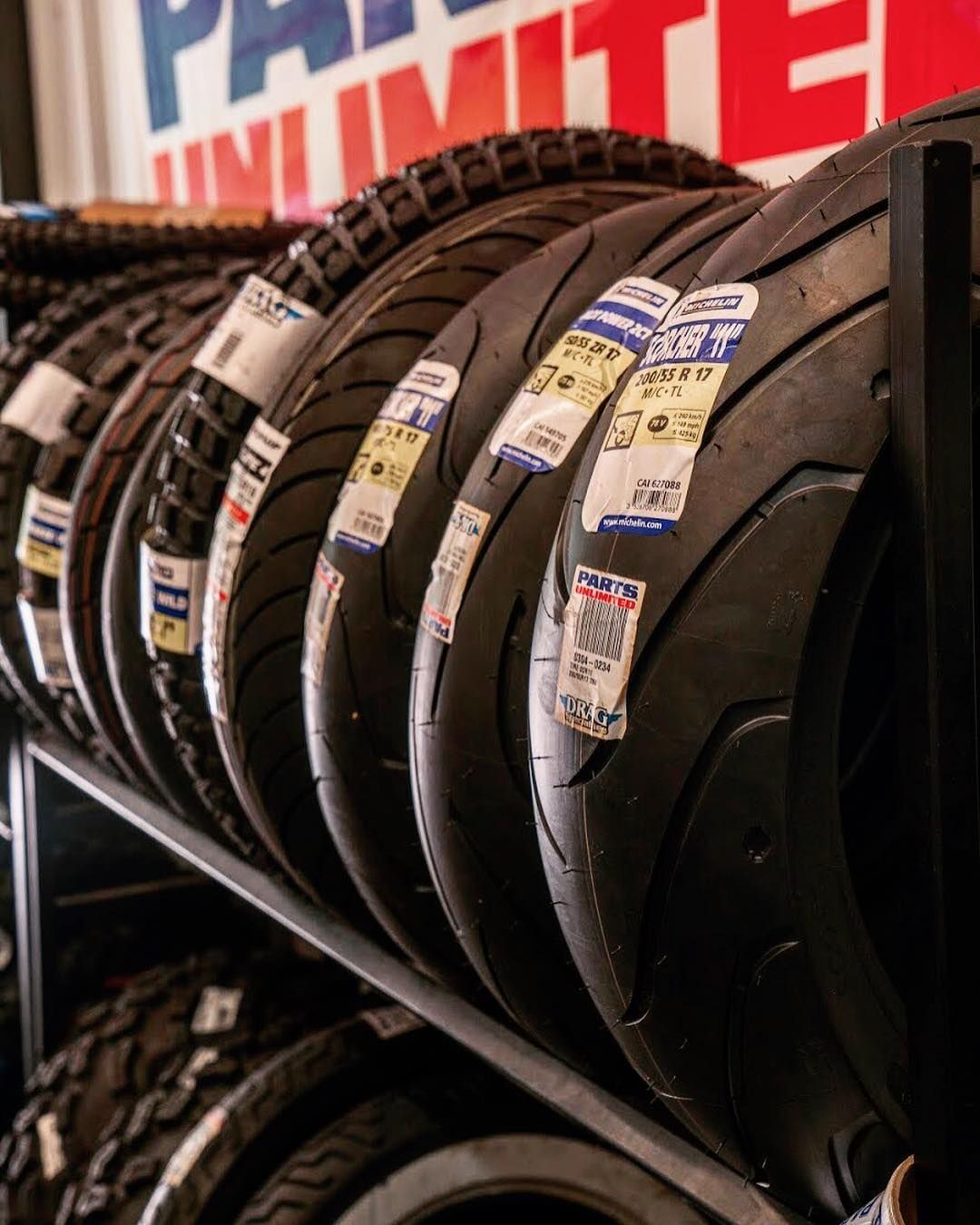 A bunch of motorcycle tires are lined up on a rack
