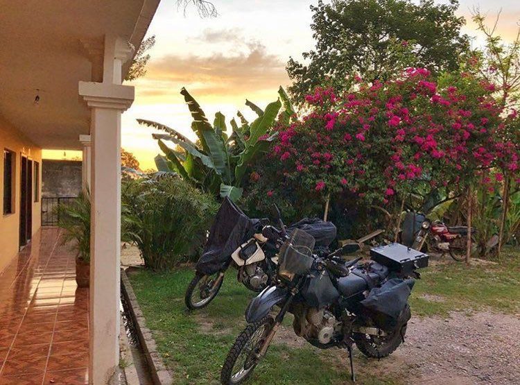 Three motorcycles are parked in front of a house.