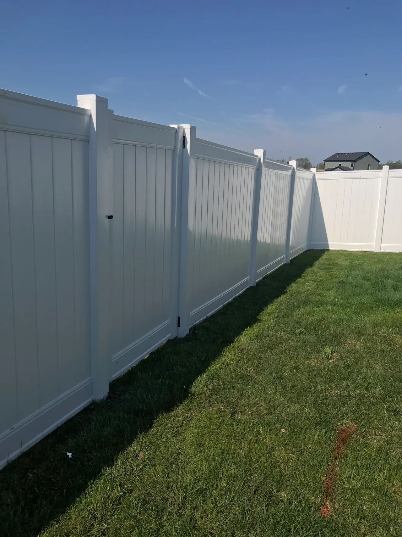 White Vinyl Fence Surrounds a Lush Green Yard — Bondurant, IA — Titan Fence LLC