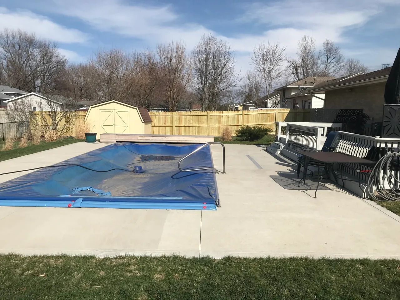 Large Swimming Pool with a Blue Cover in a Backyard — Bondurant, IA — Titan Fence LLC
