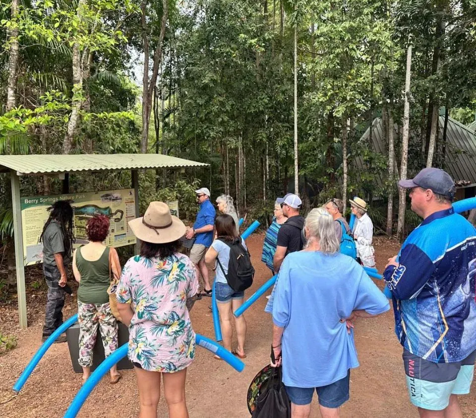 Group of People Standing Around a Sign in a Wooded Area — Litchfield VIP Tours In Darwin City, NT