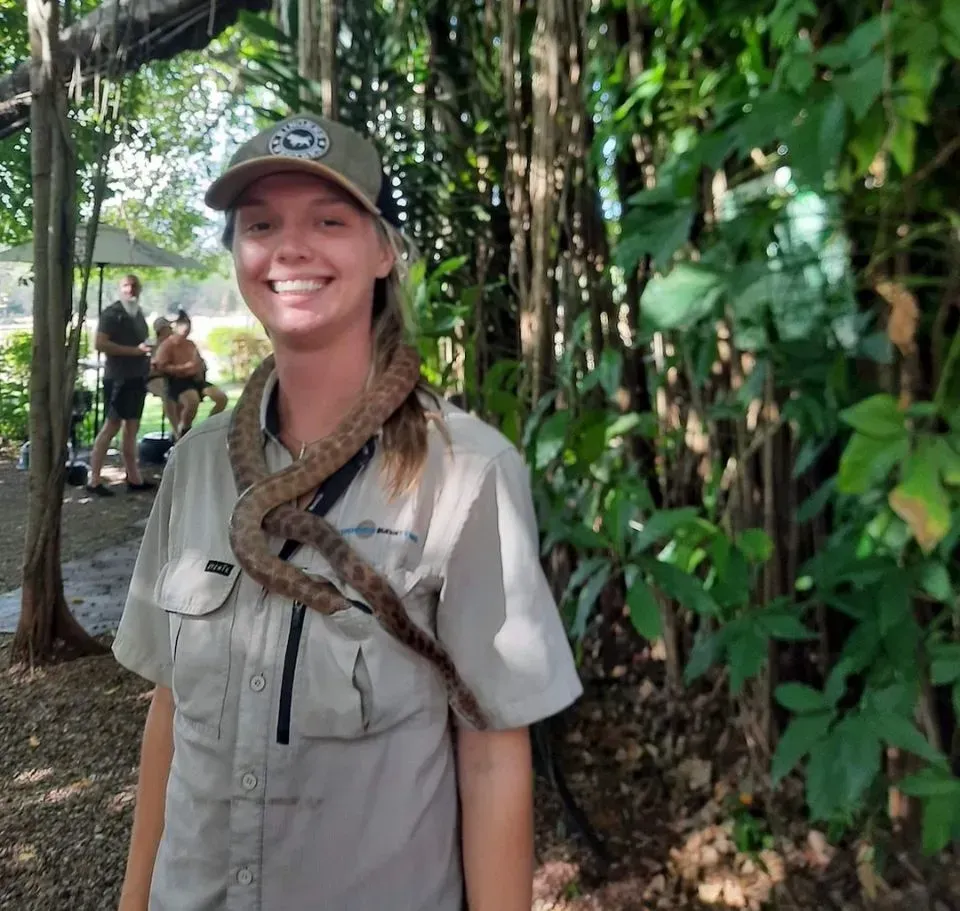 Woman With Snake Around Neck, Smiling Outdoors Near Trees — Litchfield VIP Tours In Darwin City, NT