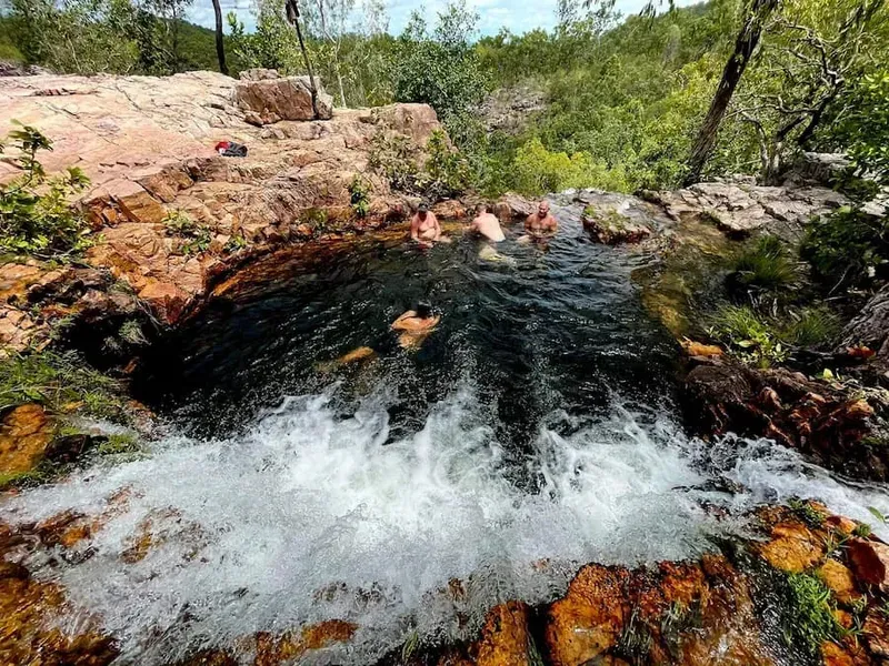 People Relaxing in a Natural Pool With Cascading Water — Litchfield VIP Tours In Darwin City, NT