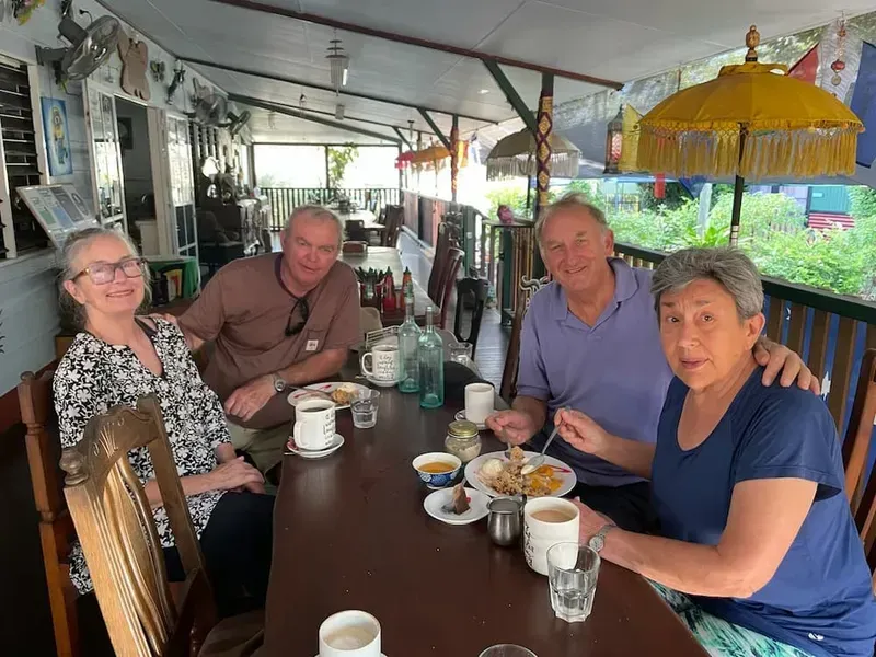 Four People Seated at a Table, Eating and Smiling — Litchfield VIP Tours In Darwin City, NT