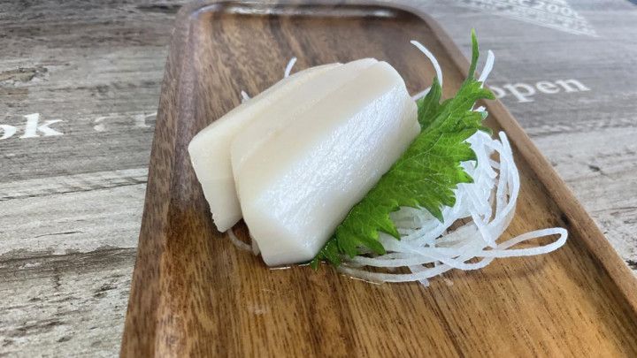 A close up of a piece of food on a wooden tray.