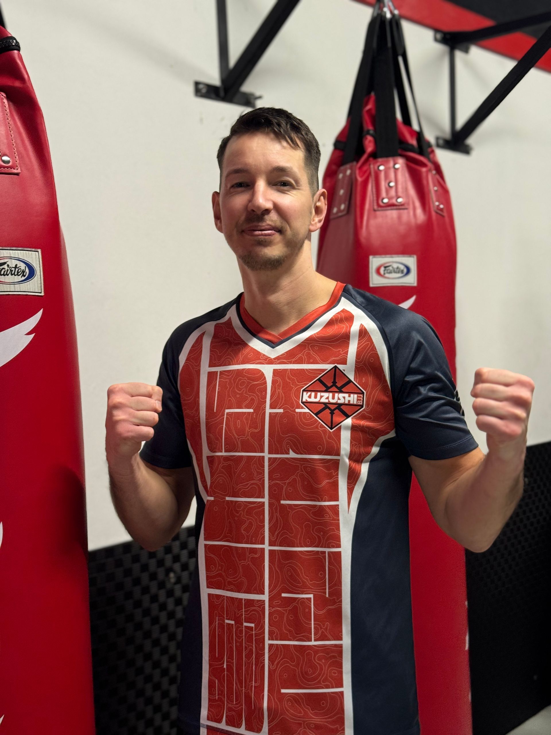 Rote und weiße Boxhandschuhe hängen an einer weißen Wand.