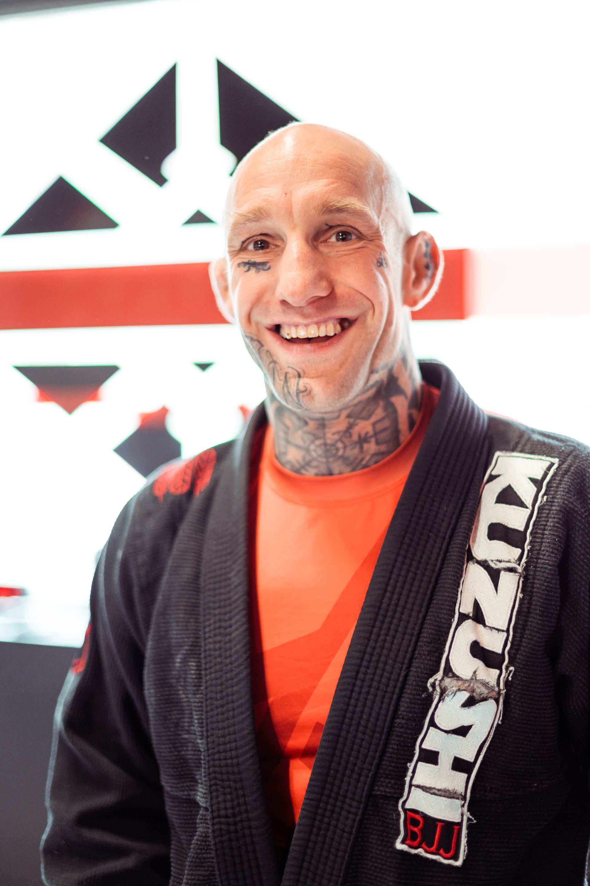 Zwei Männer im Jiu-Jitsu-Kampf; einer im schwarzen Gi hält seinen Gegner im blauen Gi kopfüber. Wettkampfsituation.