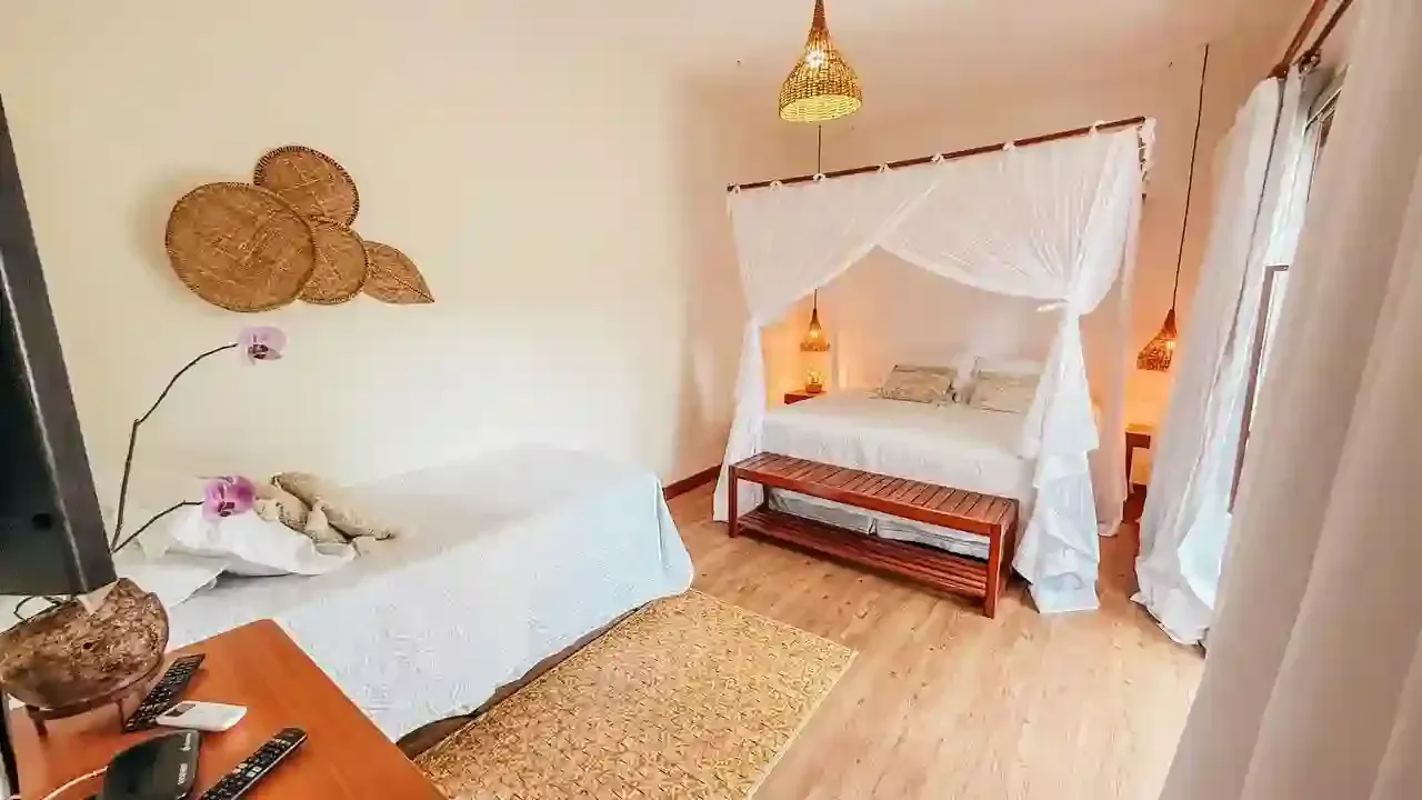 Um quarto com uma cama de dossel e um banco - pousada-recanto-caxando