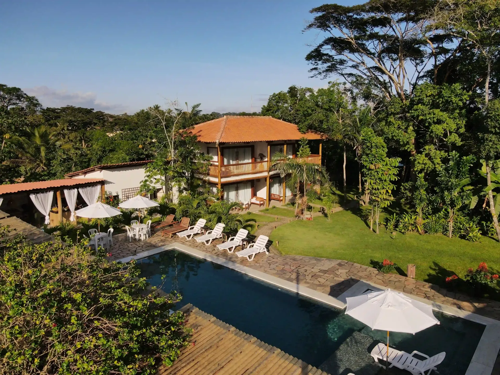 Uma casa grande com uma piscina na frente - pousada-recanto-caxando