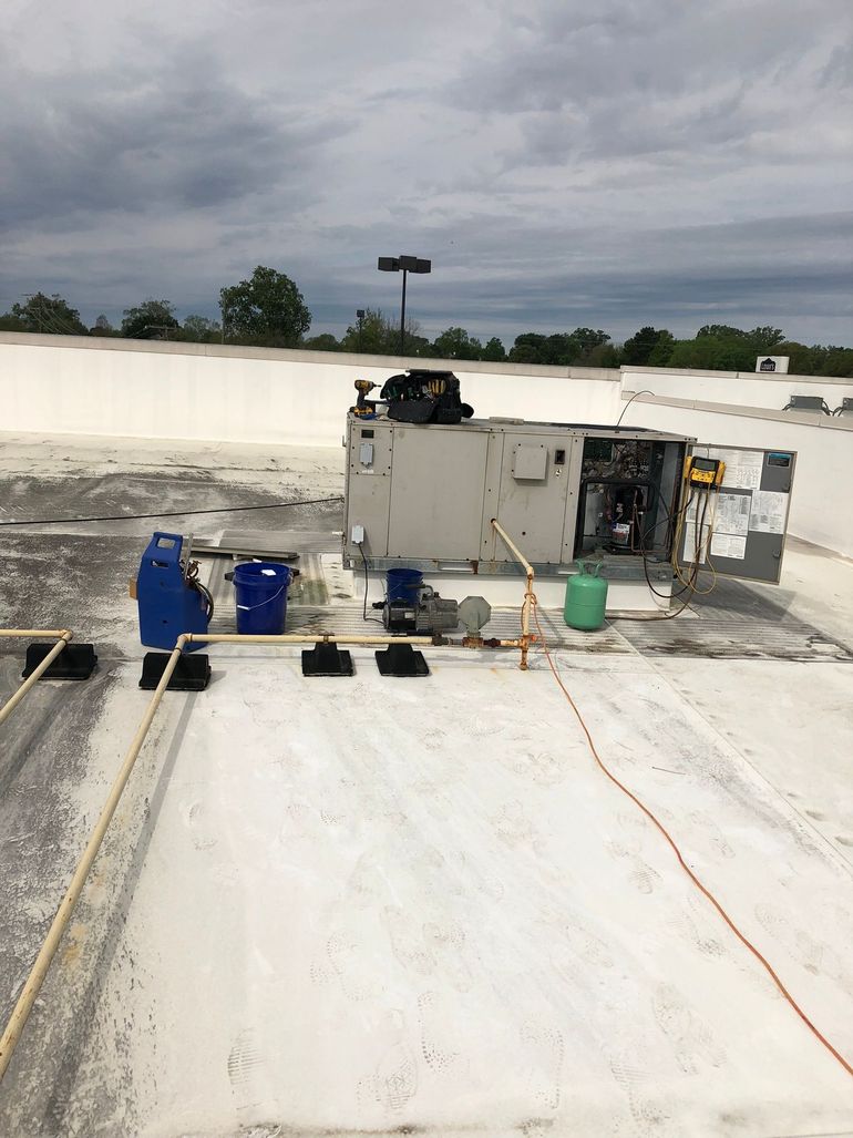 A man is cleaning the roof of a building with a broom.