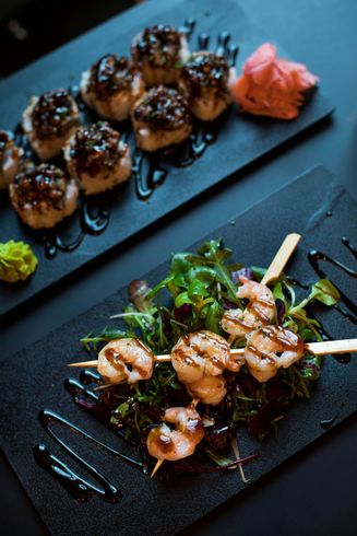 There are two plates of food on the table , one of which is a salad with shrimp on skewers. There are two plates of food on the table , one of which is a salad with shrimp on skewers.