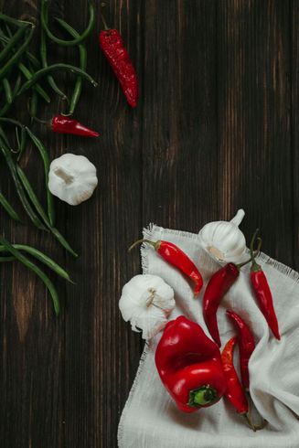 Red peppers , garlic and green beans on a wooden table. Red peppers , garlic and green beans on a wooden table.