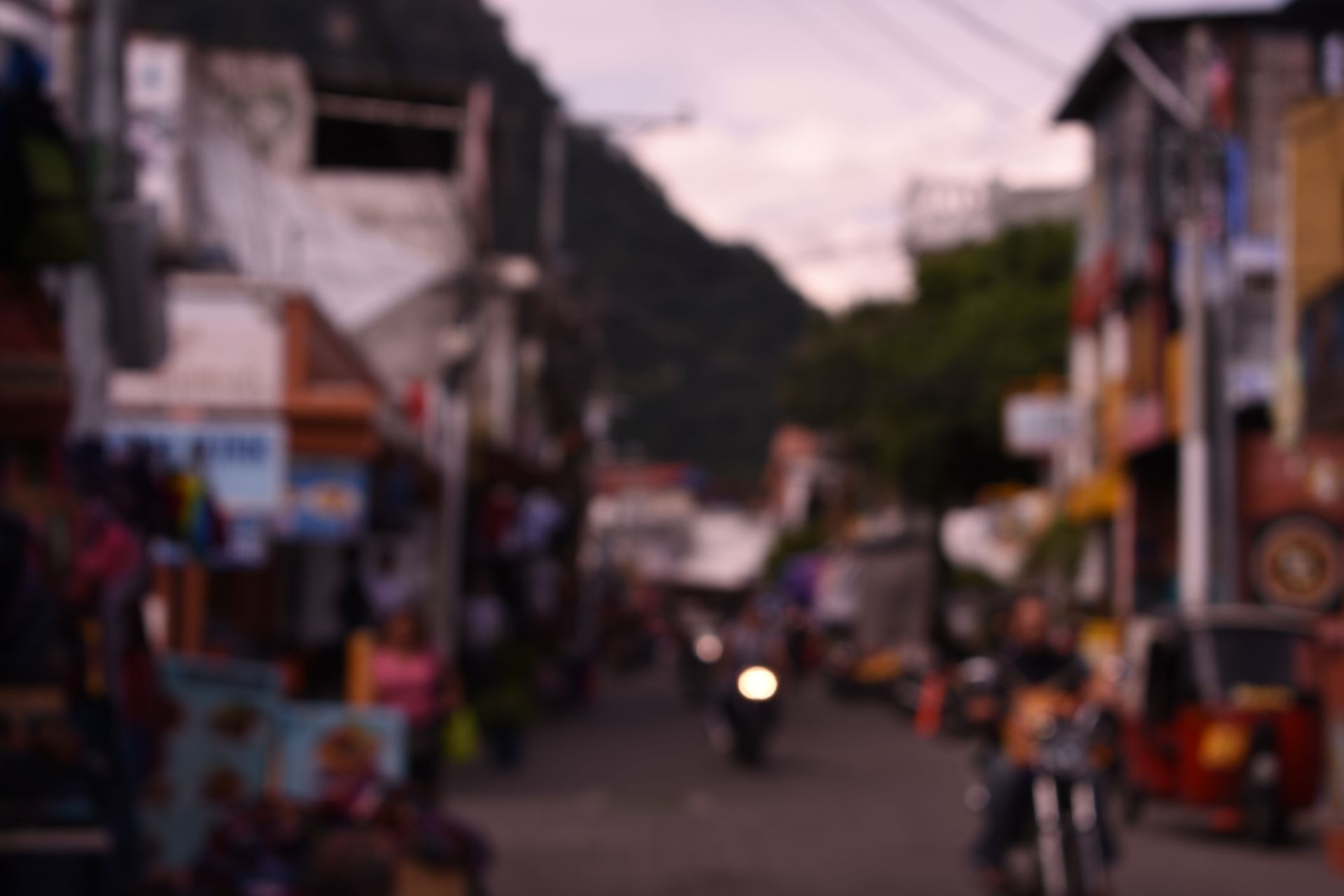 A blurry picture of people riding motorcycles down a street.