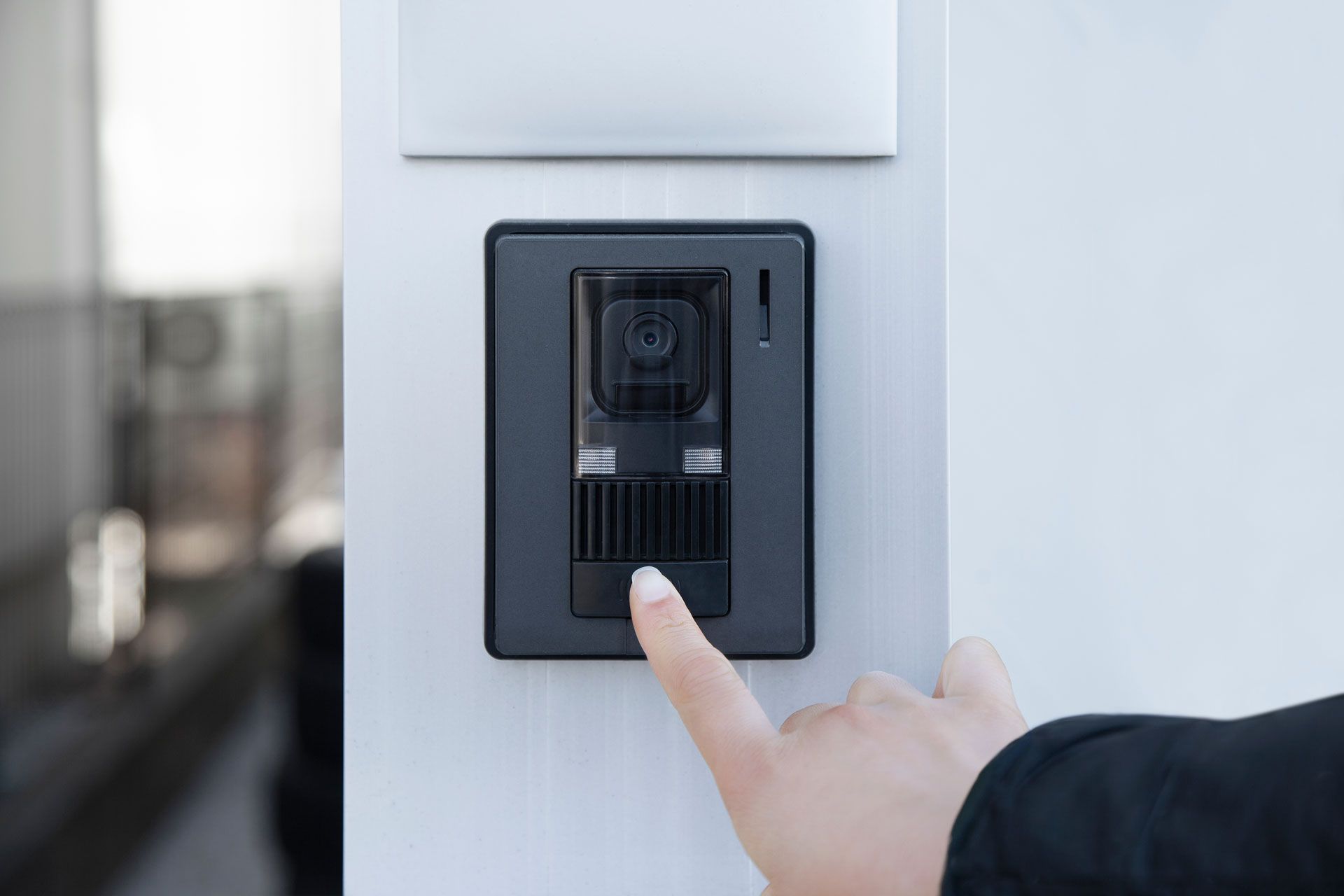 A person is pressing a button on a wall with their finger.