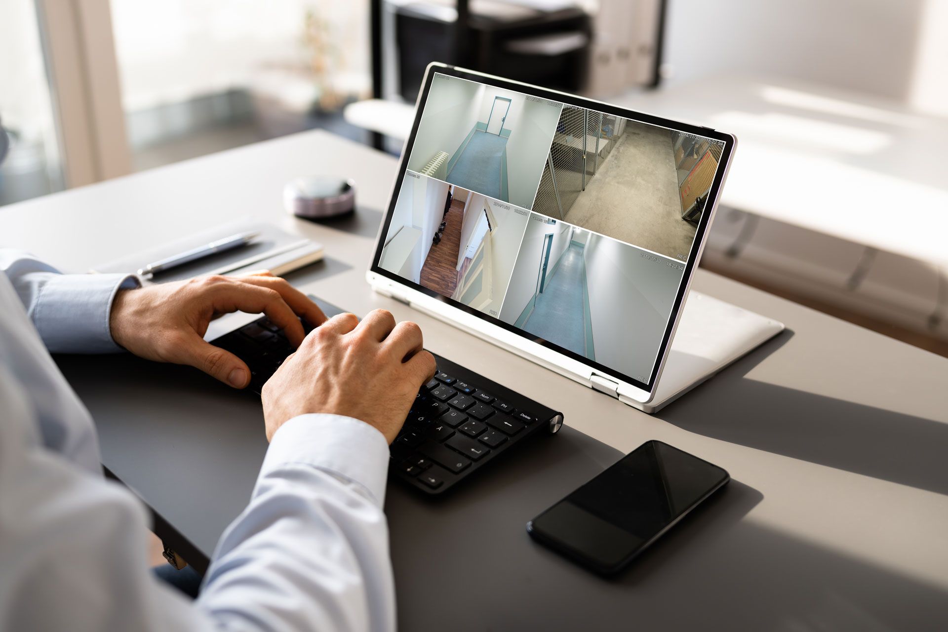 A man is sitting at a desk using a laptop computer.
