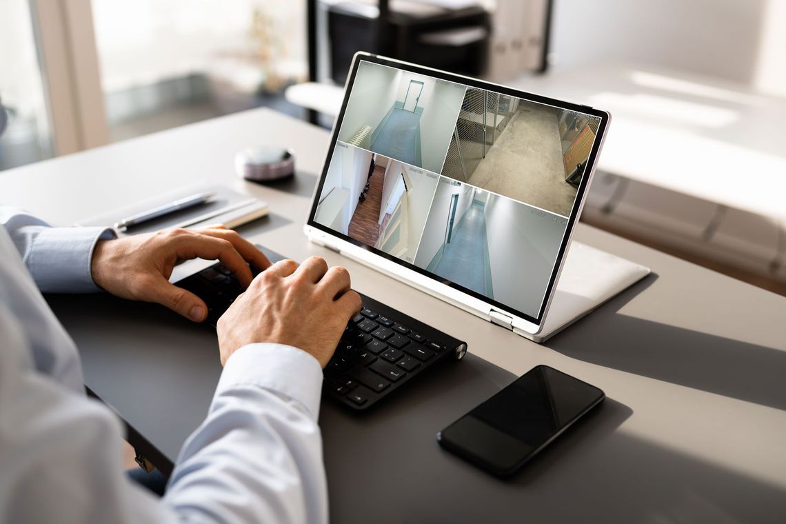 A man is sitting at a desk using a laptop computer.