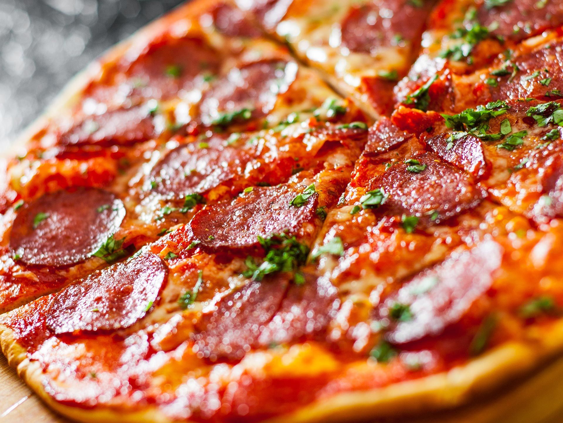 Sliced pepperoni pizza with mozzarella, salami, tomatoes, peppers, spices, and basil. Sliced pepperoni pizza with mozzarella, salami, tomatoes, peppers, spices, and basil.