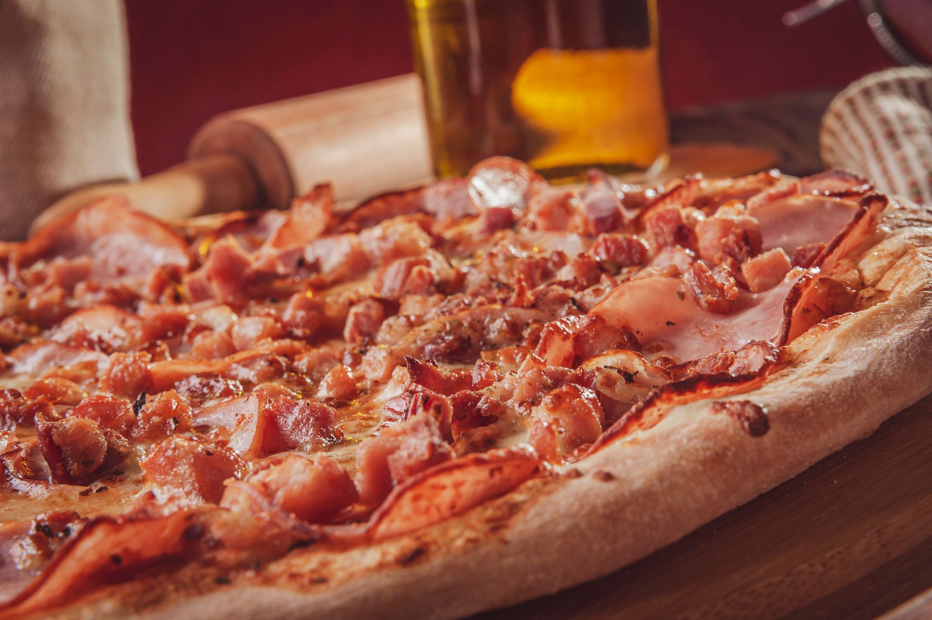 Italian pizza piled high with bacon, sausage, cheese, meat & fresh tomatoes.