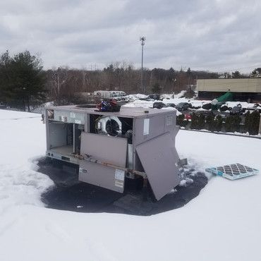 An air conditioner is sitting in the middle of a snow covered field.
