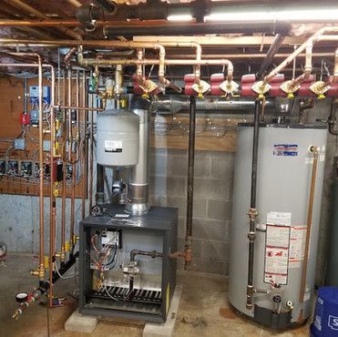 There are two water heaters in the basement of a house.