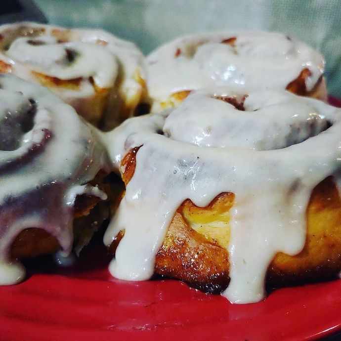 A close up of cinnamon rolls on a red plate