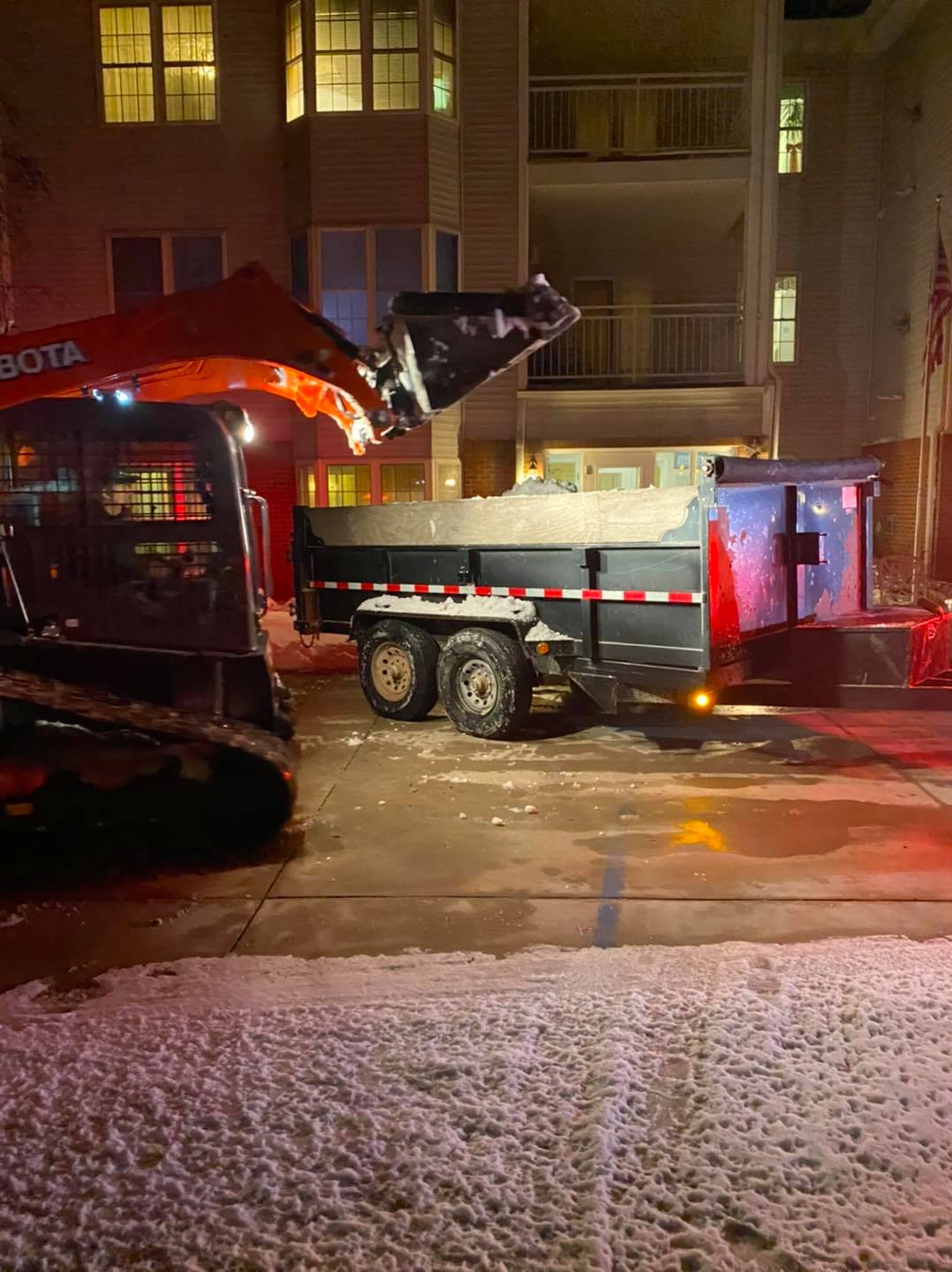Skid loader and dump truck hauling snow during Central Iowa storm – CD’s Lawn Care