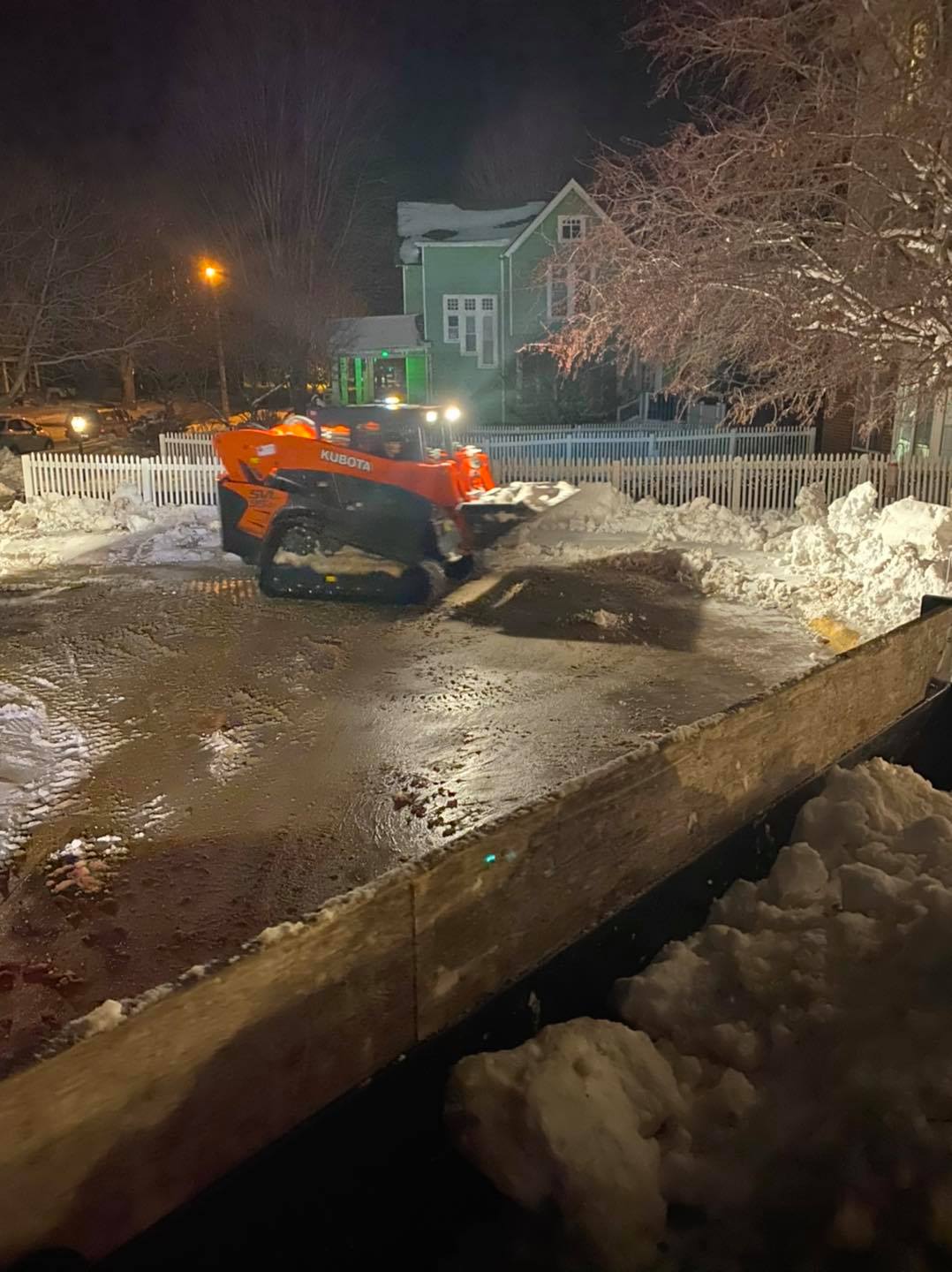 Skid loader and dump truck hauling snow during Central Iowa storm – CD’s Lawn Care