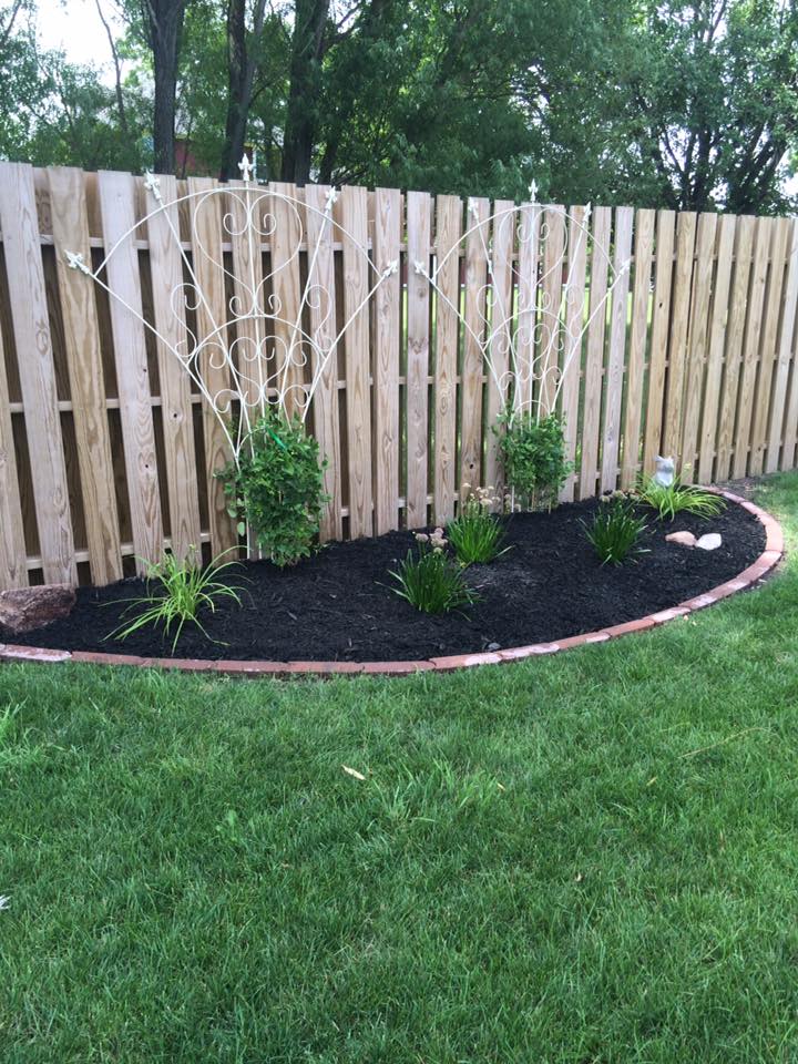 Fresh mulch being installed in residential flower bed by CD’s Lawn Care