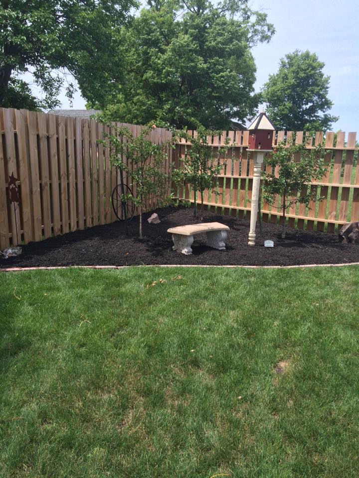 Fresh mulch being installed in residential flower bed by CD’s Lawn Care