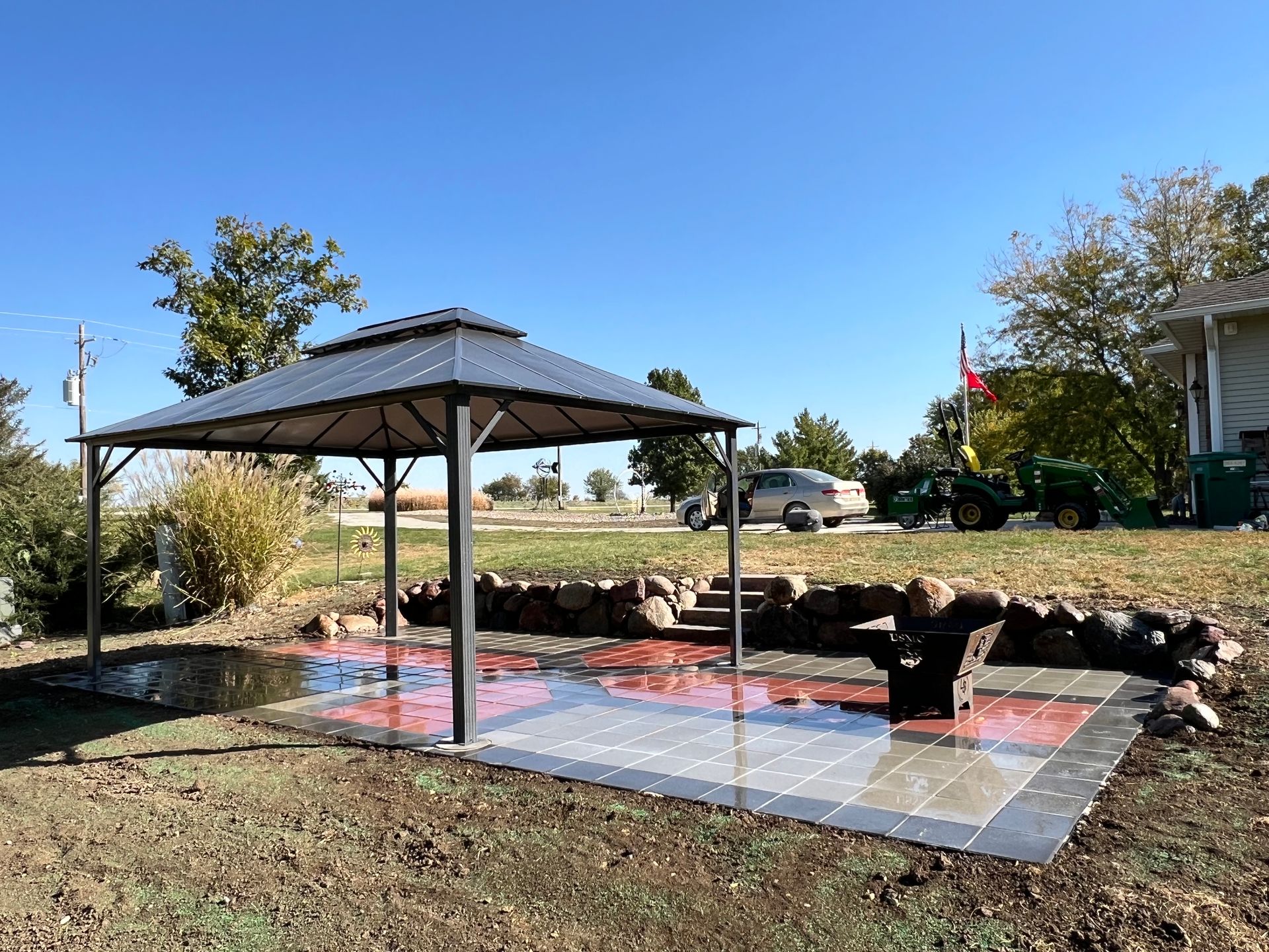 Patio with gazebo and rock retaining wall designed and built by CD’s Lawn Care in Central Iowa