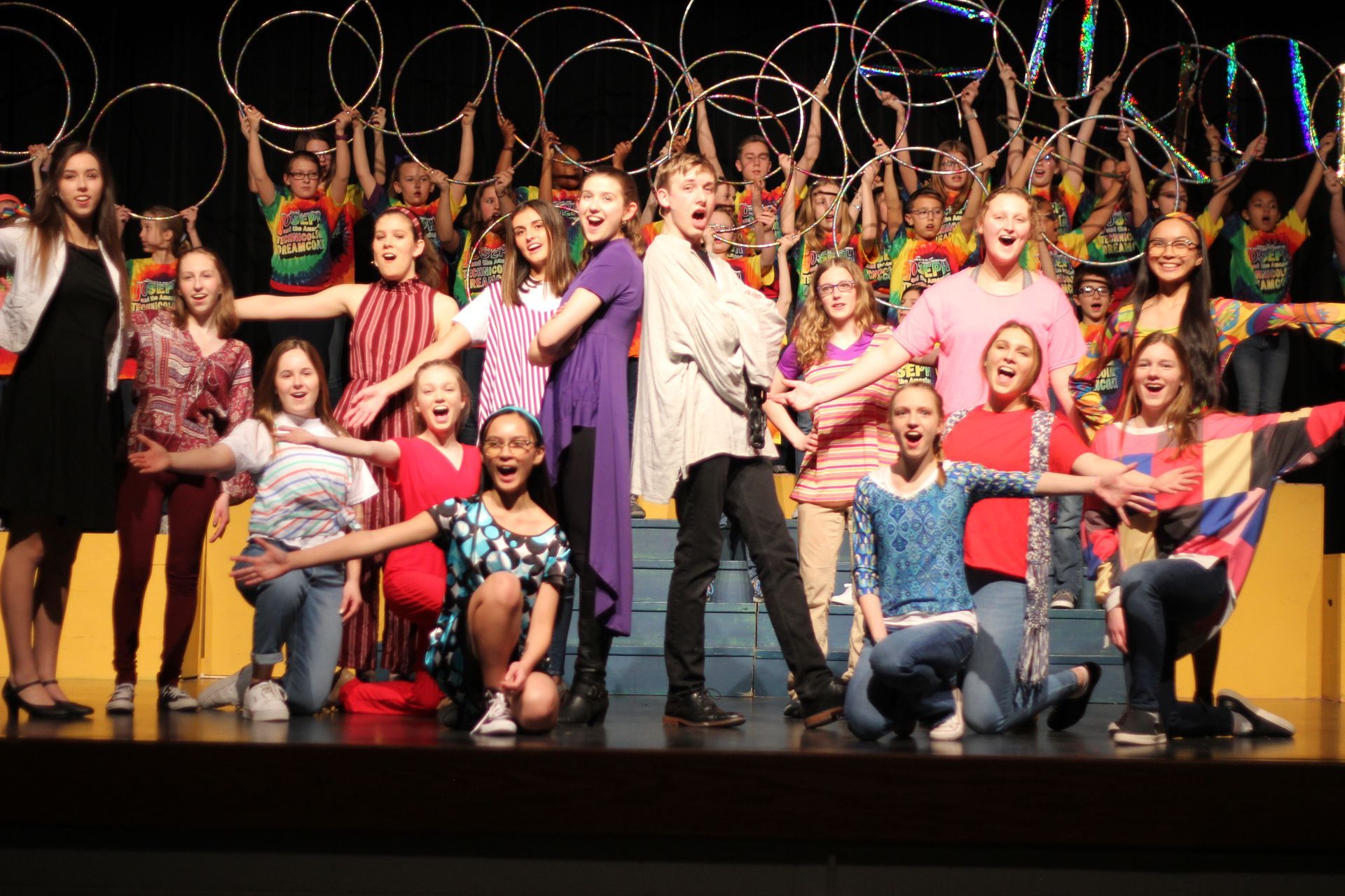 A group of young people are posing for a picture on a stage.