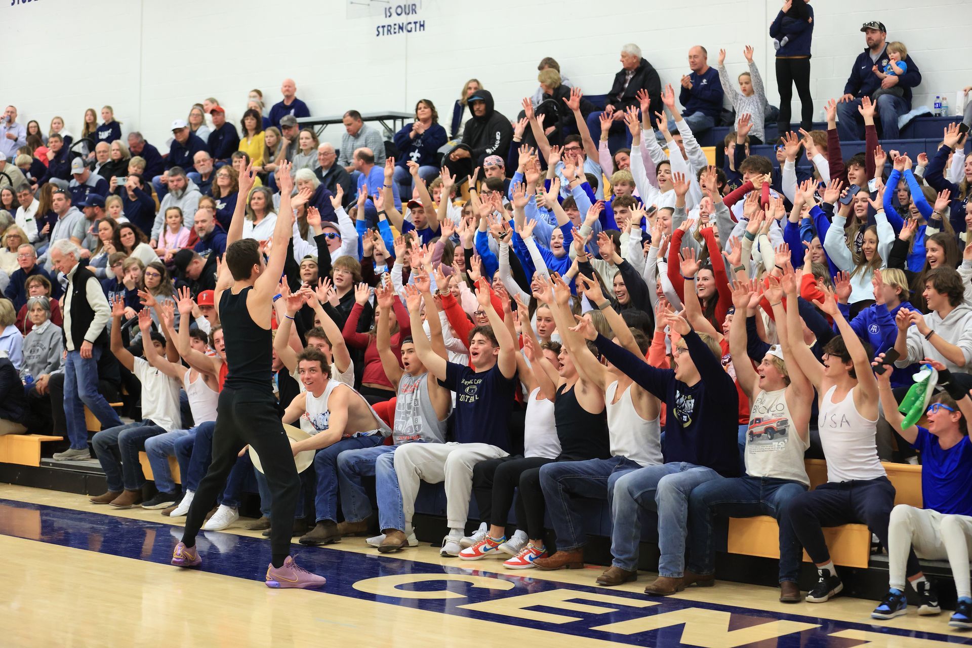 A crowd of people are watching a basketball game in a gym.