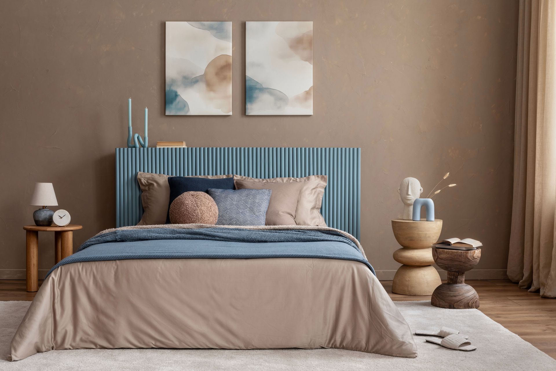 Hotel bedroom with a large bed, brown walls, and artwork. A bathroom is visible in the doorway.