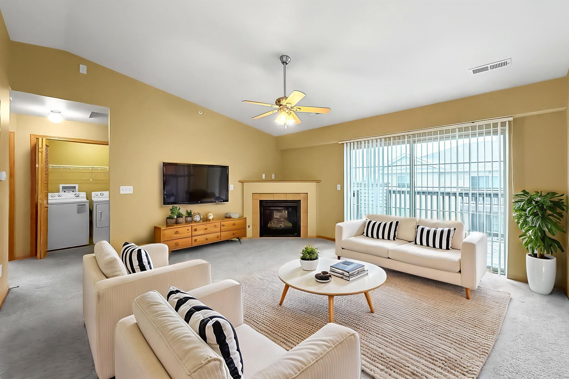 Hotel bedroom with a large bed, brown walls, and artwork. A bathroom is visible in the doorway.