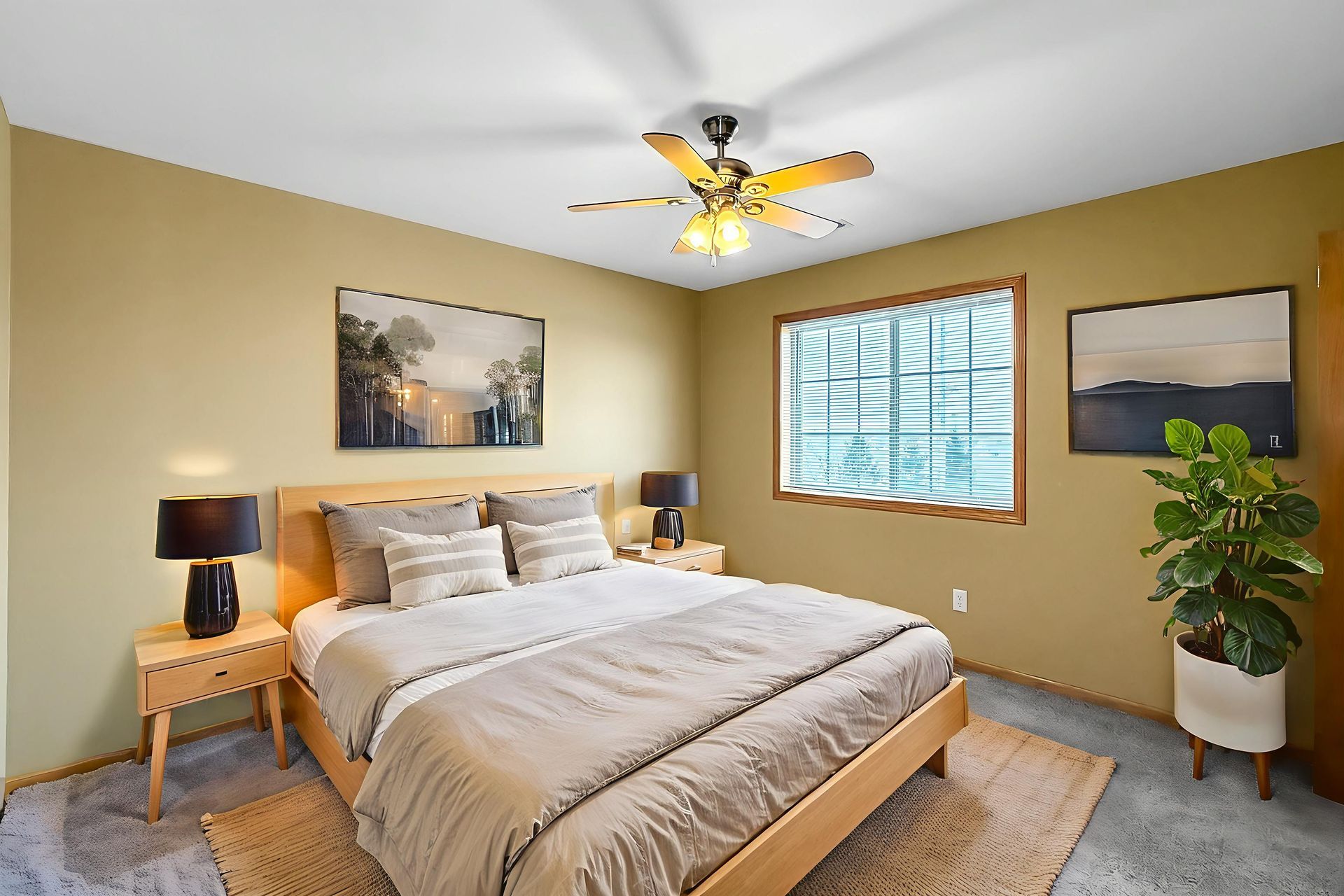 Bright living room with white sectional sofa, dresser, floor lamp, and window coverings.