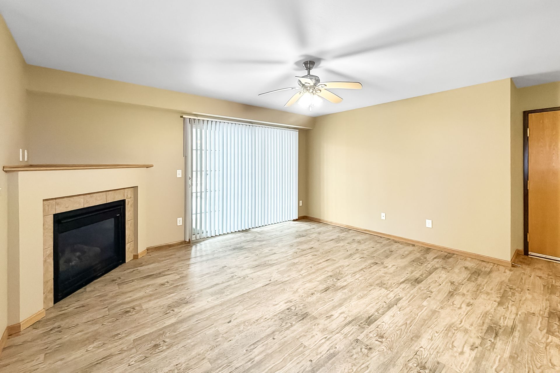 Aerial view of apartment buildings with parking, a road, and a green field.