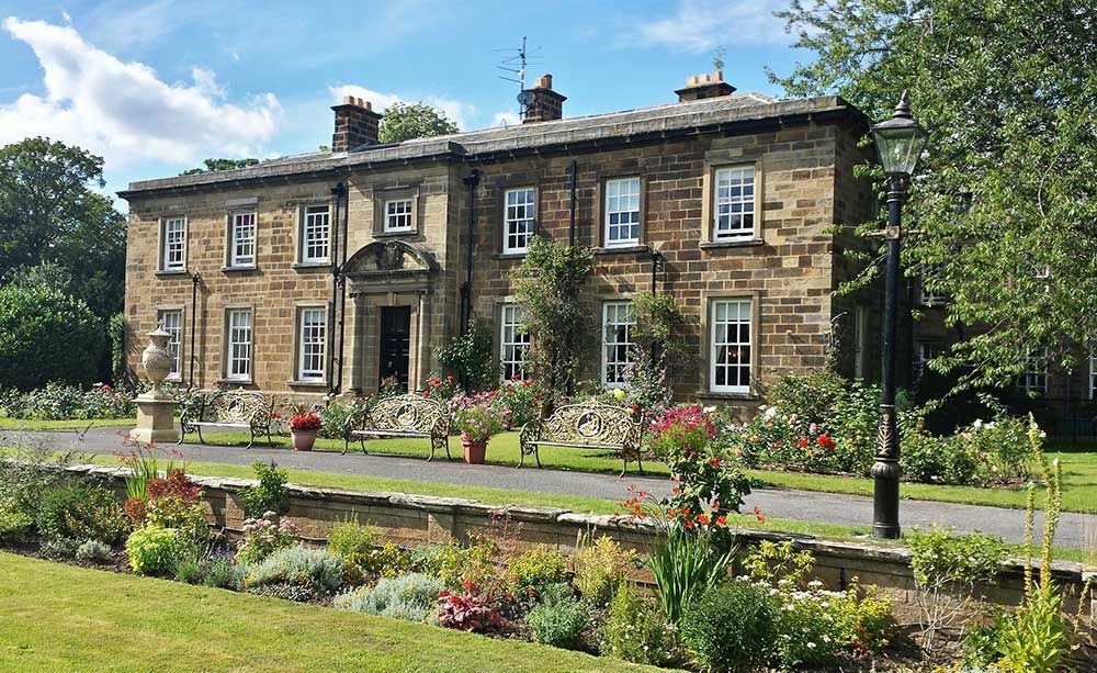 Front exterior of Nunthorpe Hall set within landscaped gardens