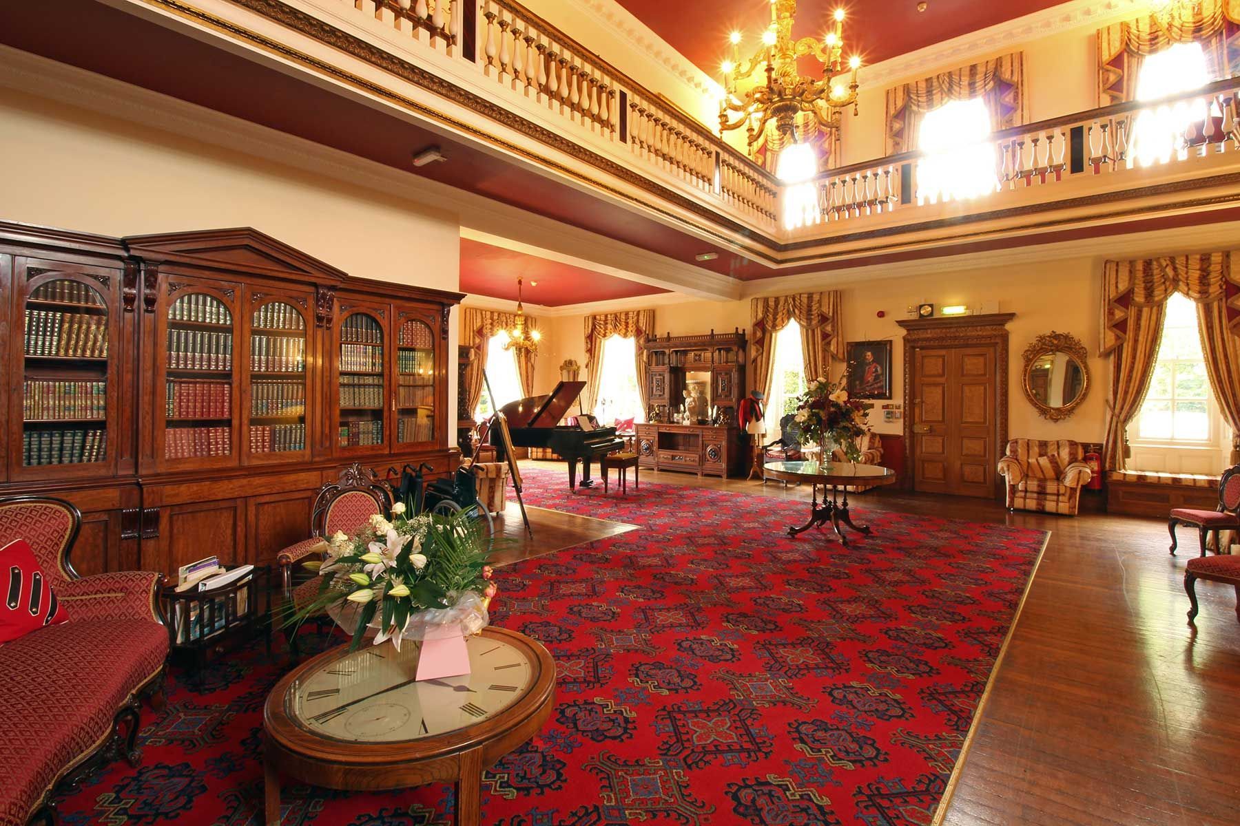 The Great Hall at Nunthorpe Hall with grand staircase, chandeliers and piano
