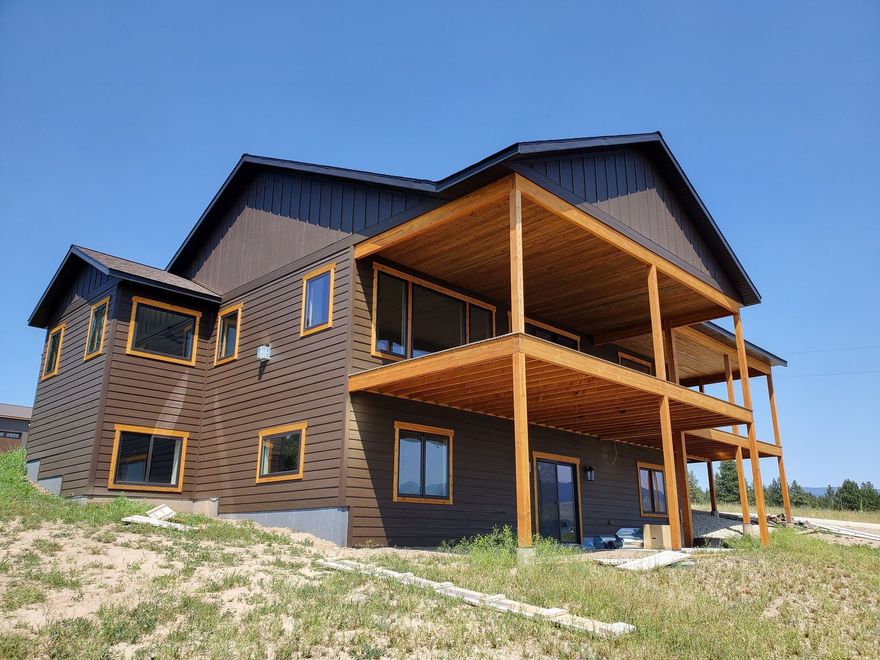 A large house is sitting on top of a grassy hill.
