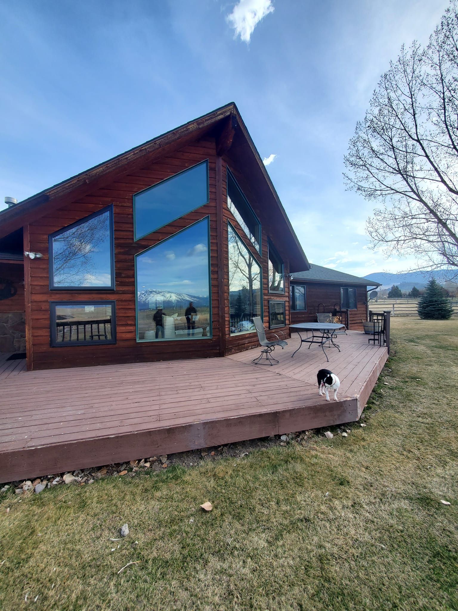 A large wooden house with a large deck in front of it.