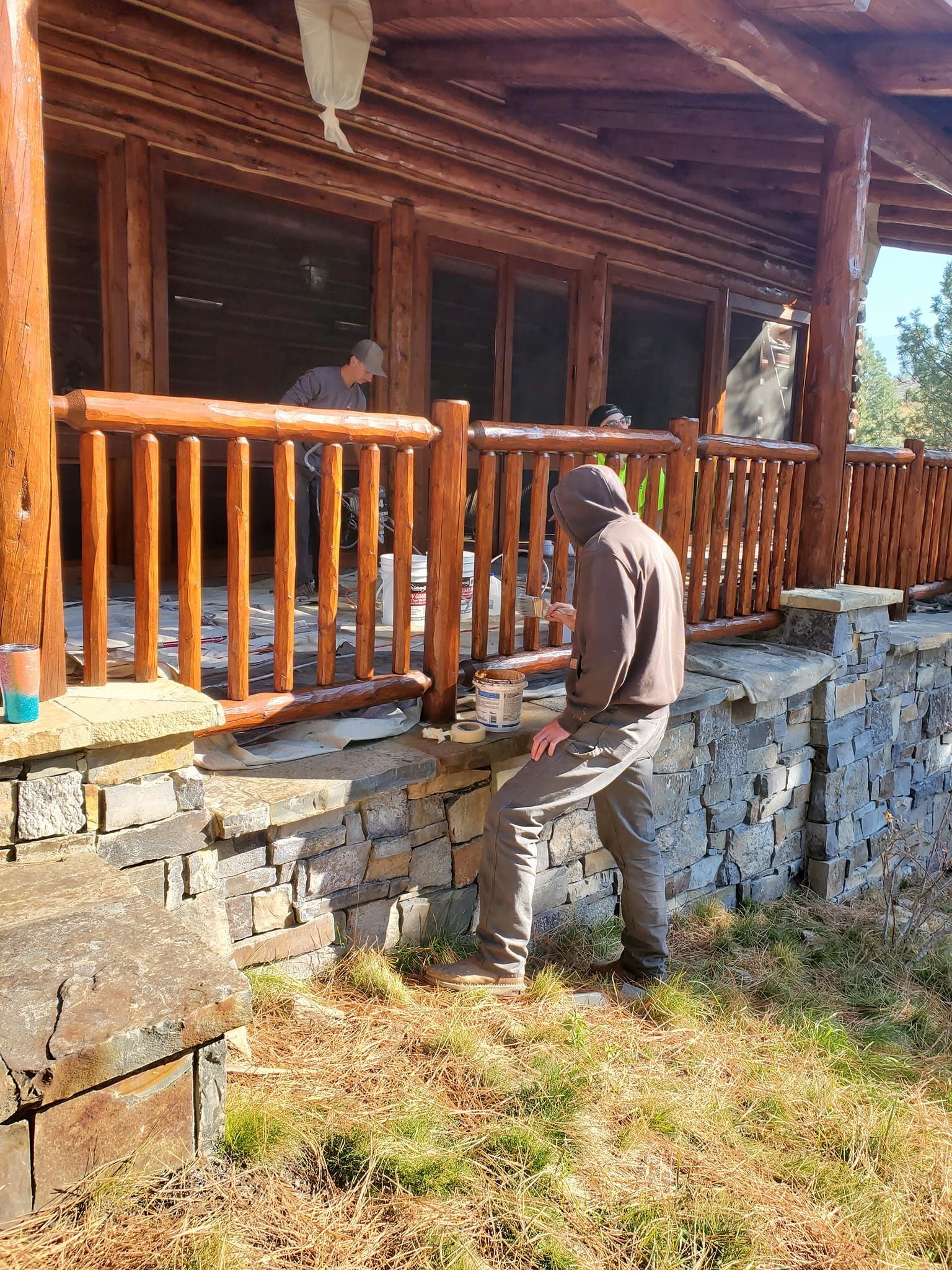 A man is standing in front of a log cabin.